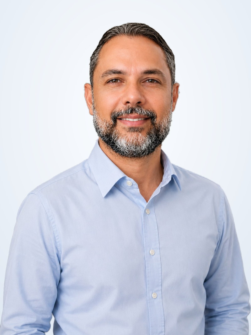 Jacson Montenegro, de camisa azul-clara, em retrato de estúdio